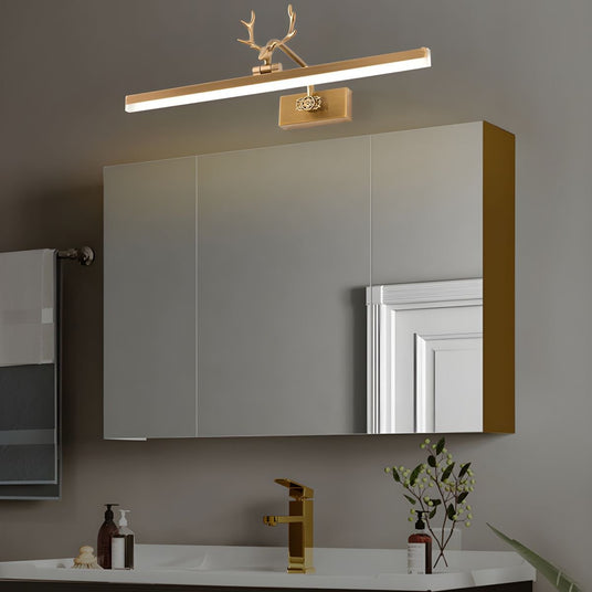 Gold antler bar lit above a mirror cabinet over a basin with bottles and a plant