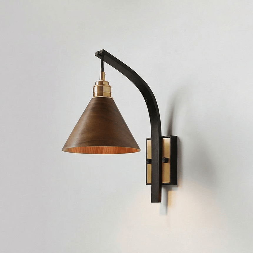 Walnut cone shade on a curved black arm with a brass wall canopy