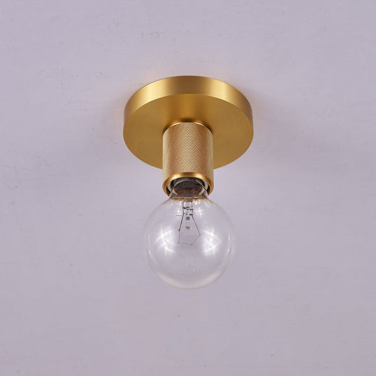 Brushed brass disc ceiling light seen from below with a clear bulb