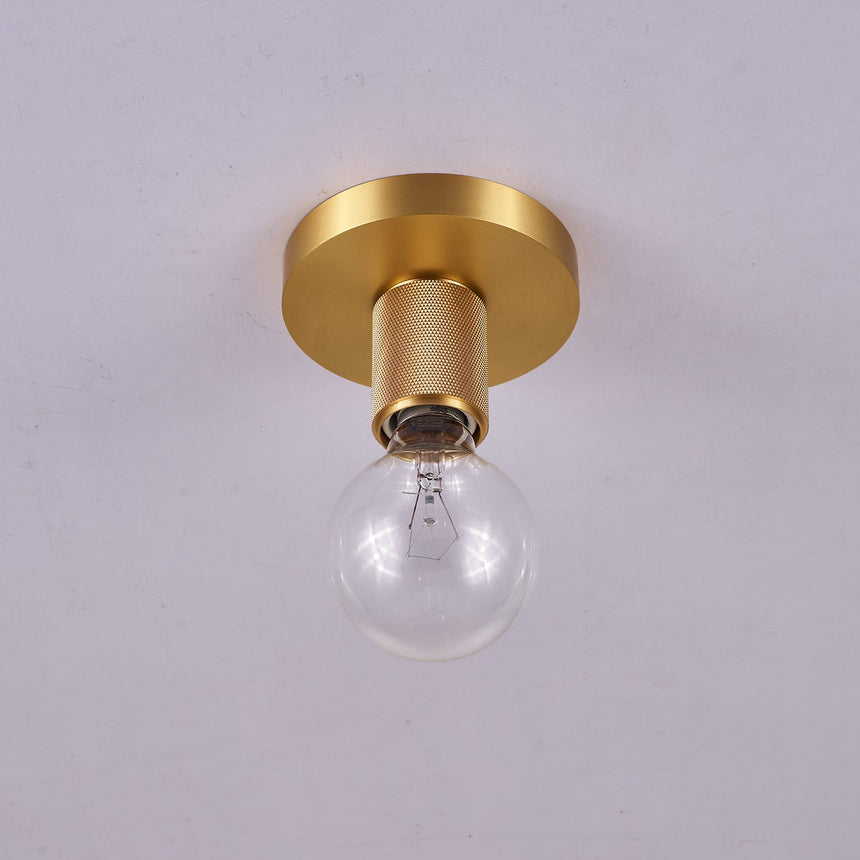 Brushed brass disc ceiling light seen from below with a clear bulb