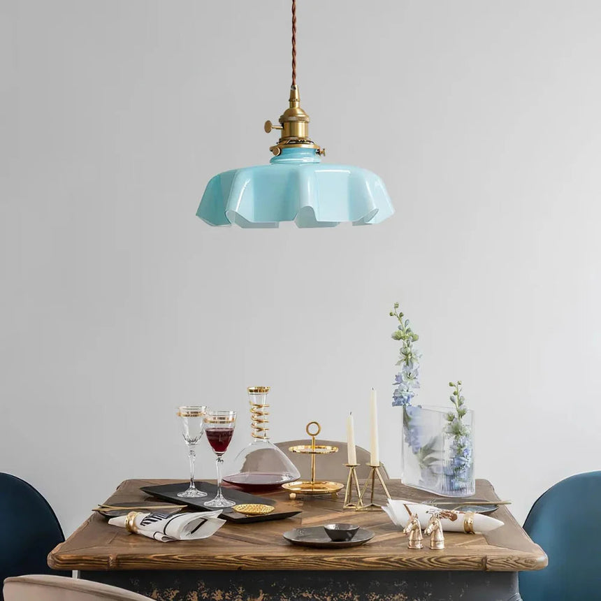 Blue scalloped shade above a laid table with glasses and blue plates