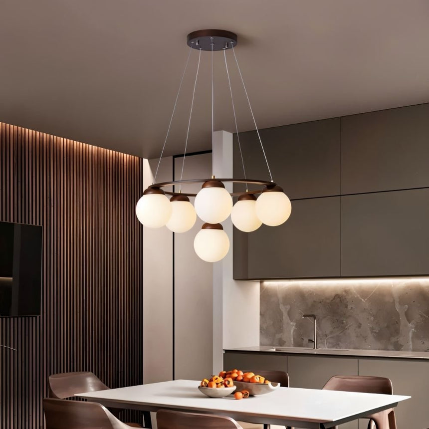 The ring lit over a kitchen dining table with chairs and a fluted wood wall