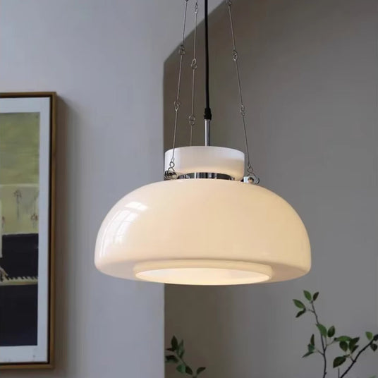 The cream dome lit in front of a framed artwork with a plant beside it