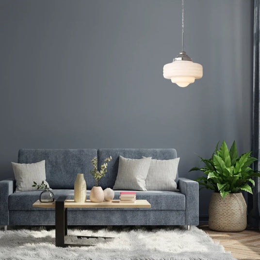 Opal shade lit above a gray sofa with cushions and a low table