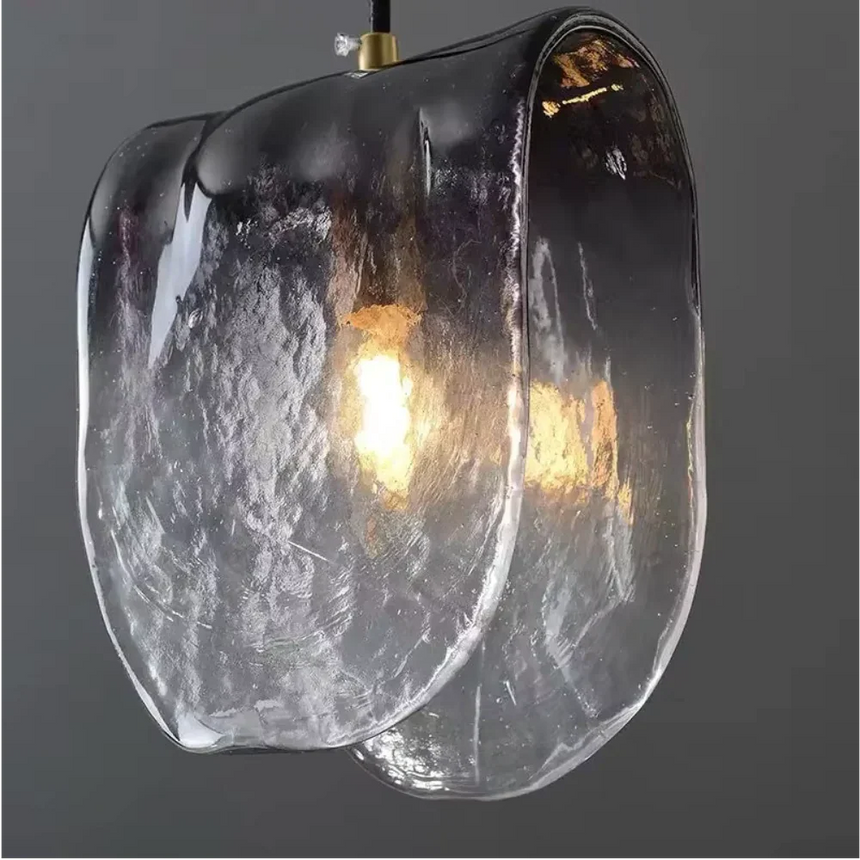 Close view of the folded glass with the filament bulb glowing inside it