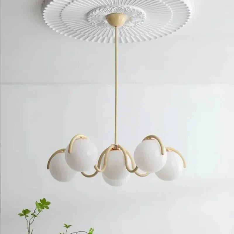 Cream curved arms with opal globes under a molded white ceiling rose