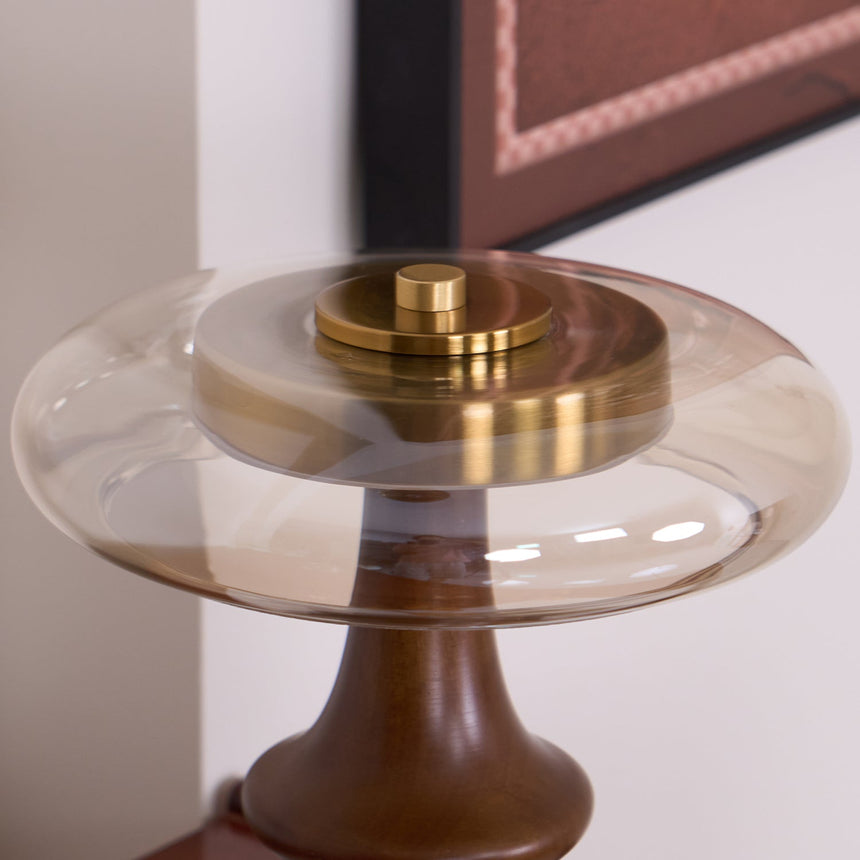 Close view of the brass cap and amber glass of the side table lamp