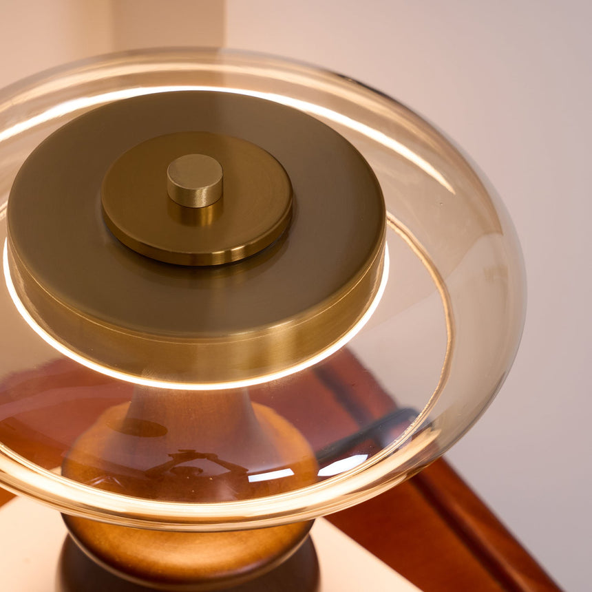 The amber glass ring of the side table lamp seen close from above