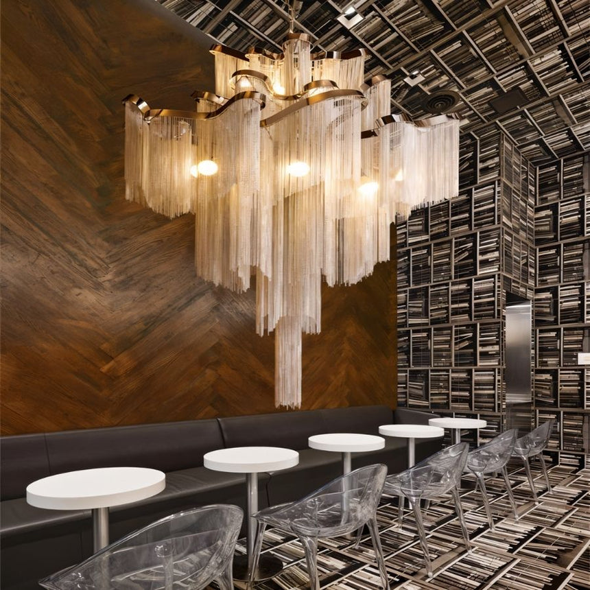 The silver version over a bar counter with round stools against a wood wall
