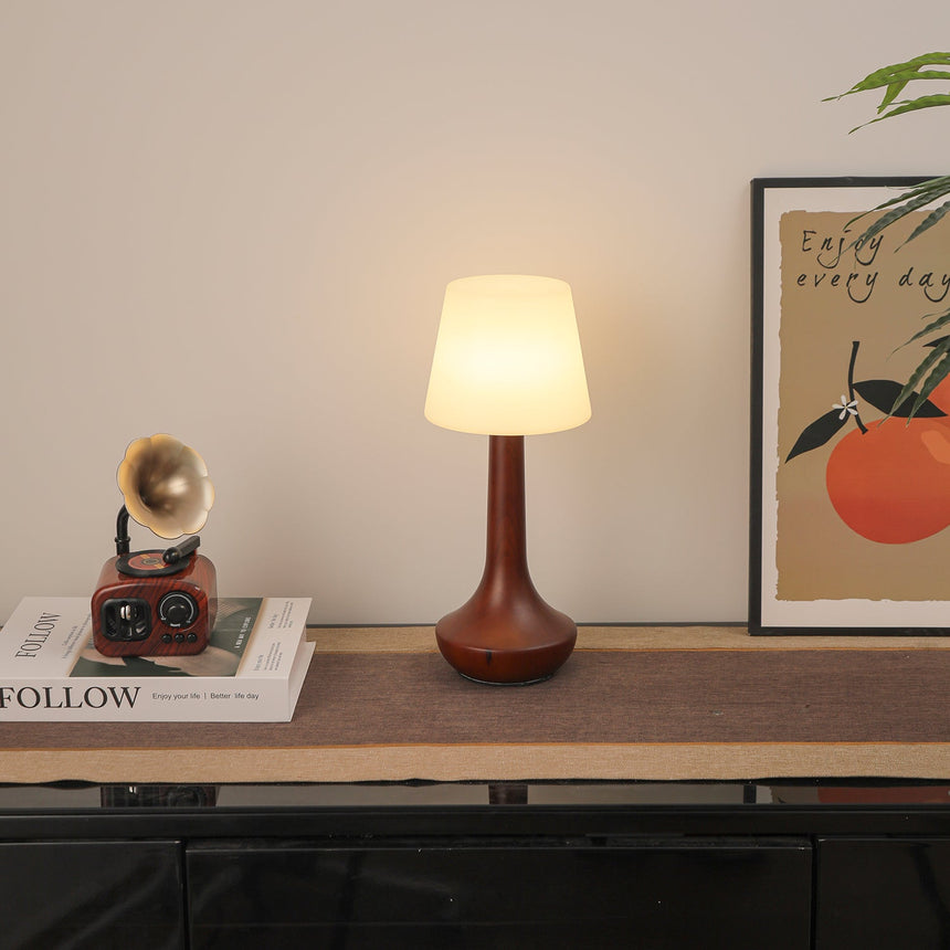 Small walnut lamp seen from an angle, the turned foot clearly visible