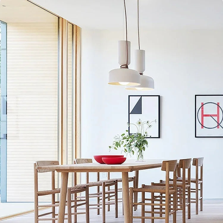Two pendants above a table in a white kitchen
