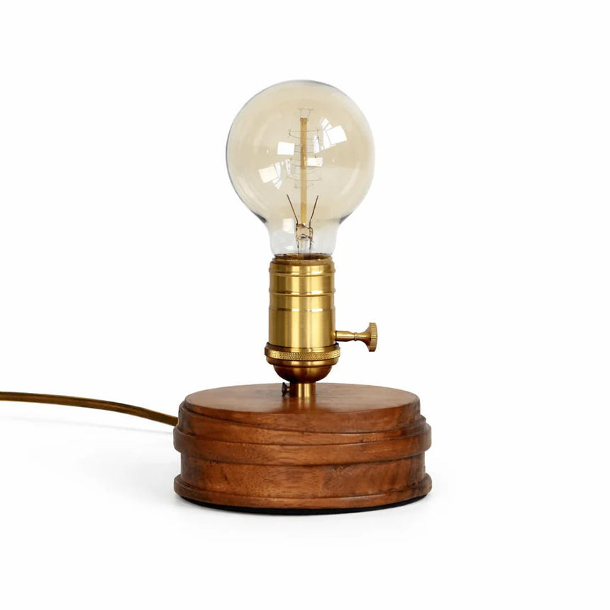 Close view of the brass holder and its rotary knob on the wood base