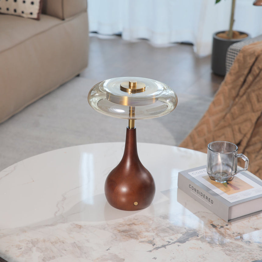 Small table lamp lit and seen from a low angle beside a glass