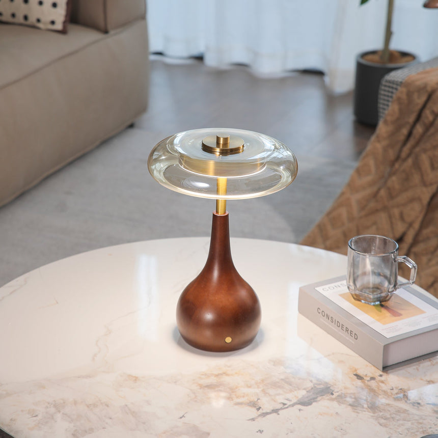 Small table lamp lit and seen from a side angle on marble