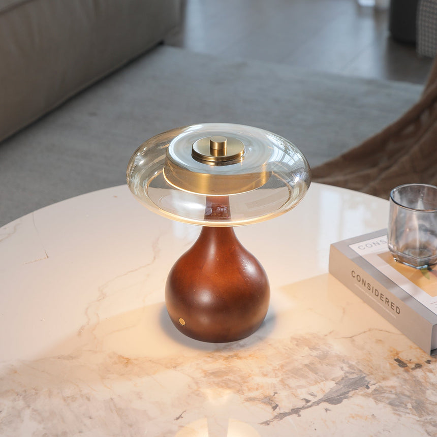 Small table lamp lit in a warm tone on a marble side table
