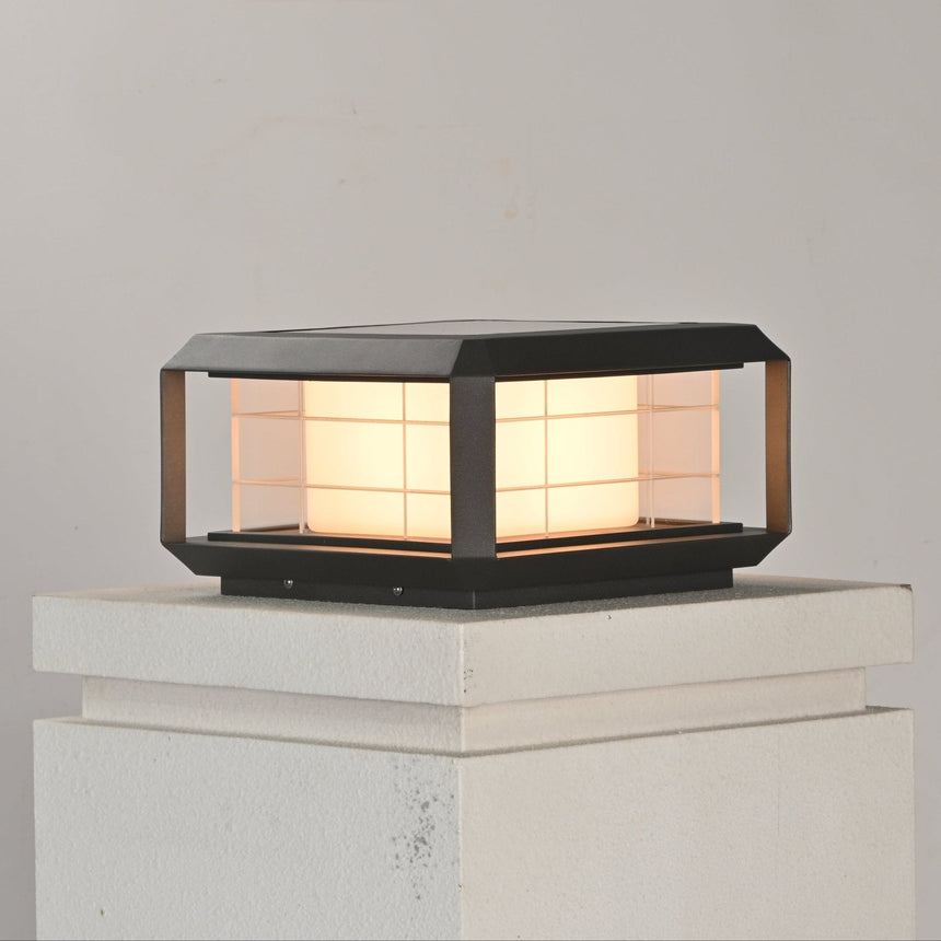 The lantern lit on a white rendered pillar cap above a stepped collar