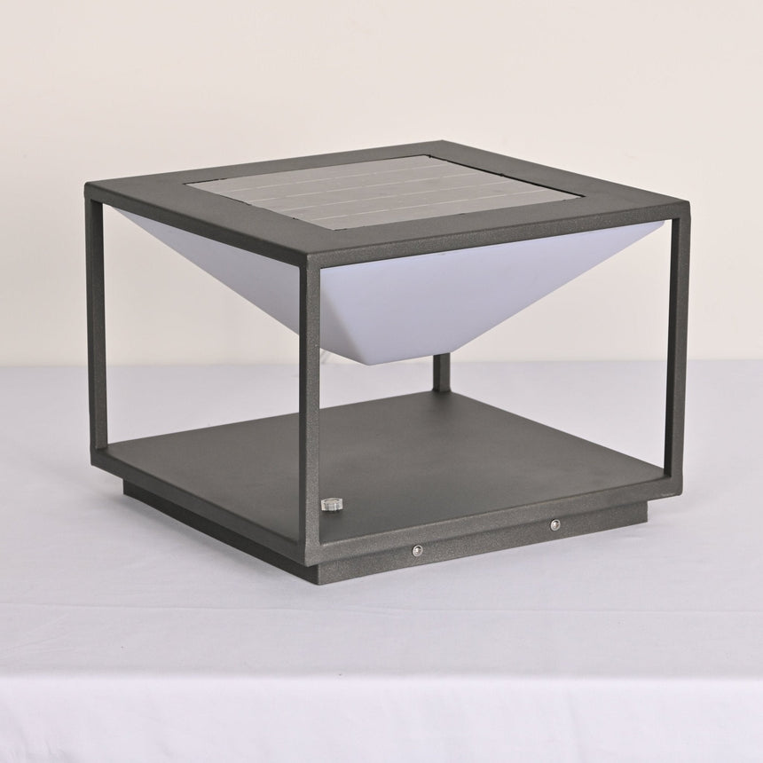 The unlit white cone hanging inside the gray open frame on a table
