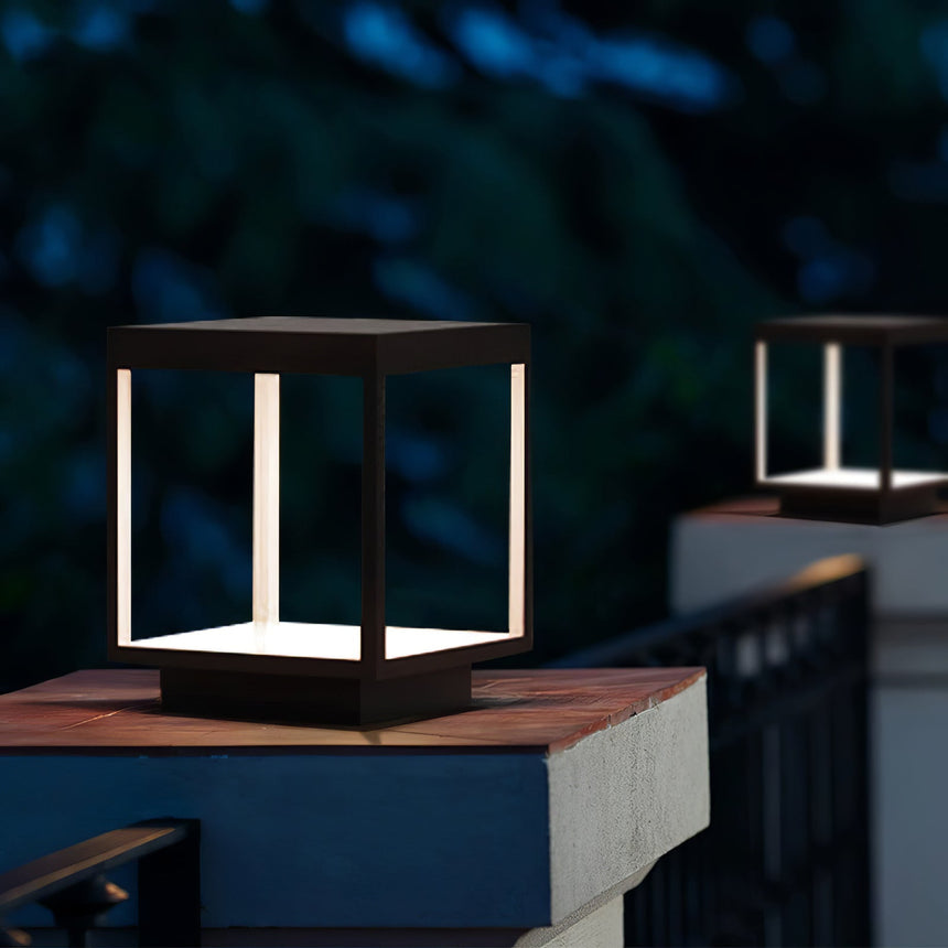 Lit frame on a timber pillar at night with a fence and trees behind