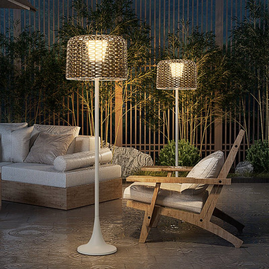 Two lit on a terrace beside a low sofa and a pair of timber chairs
