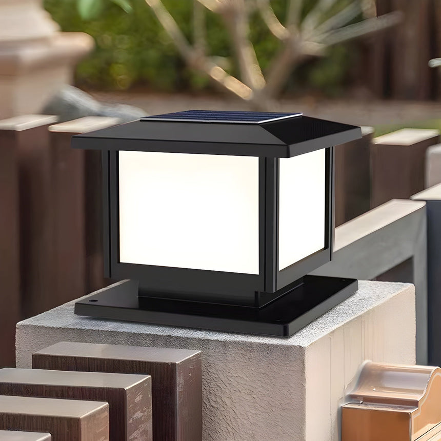 The cap lit on a brick gate pillar in a garden with a timber fence
