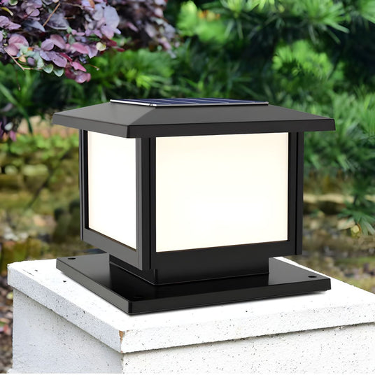 Lit cap on a white rendered pillar with flowering planting beside it