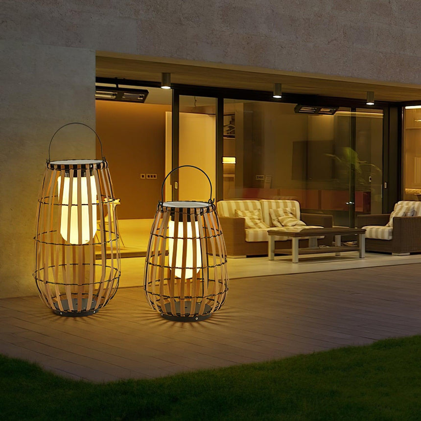 Two lanterns lit on a lawn outside a modern house with a lit terrace