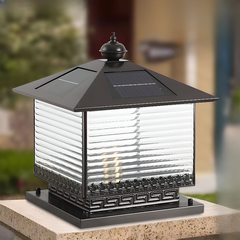 The lantern glowing on a pillar against a pale rendered garden wall