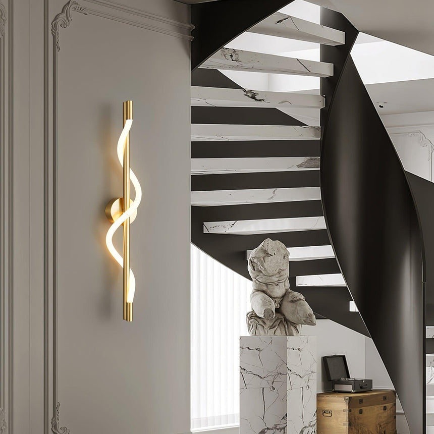 The lit spiral beside a black spiral staircase and a stone bust