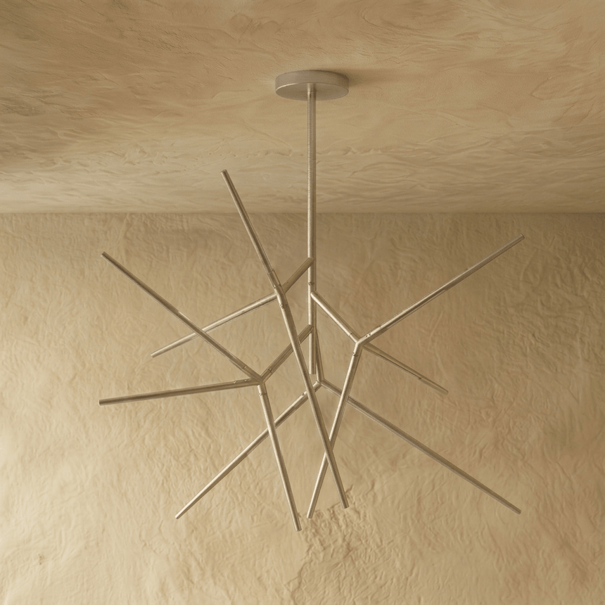 The chrome fitting turned on its axis, arms crossing at several depths