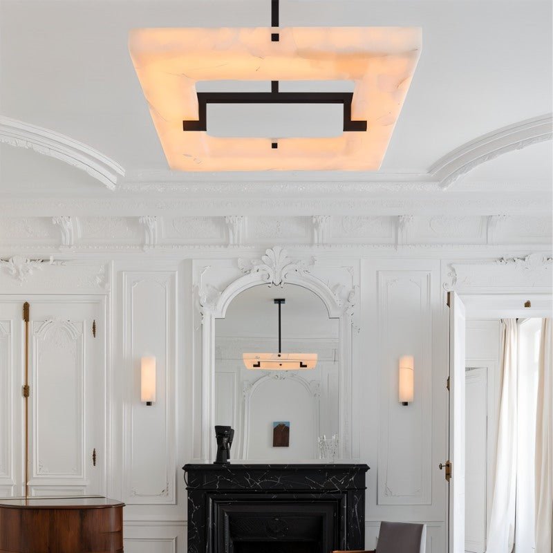 The lit square in a white room with a fireplace, a mirror and wall sconces