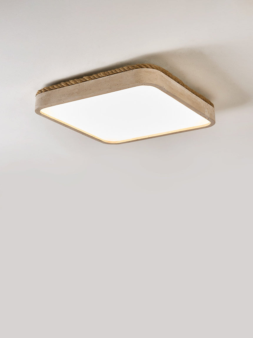 Square travertine ceiling light shown at an angle on a plain backdrop