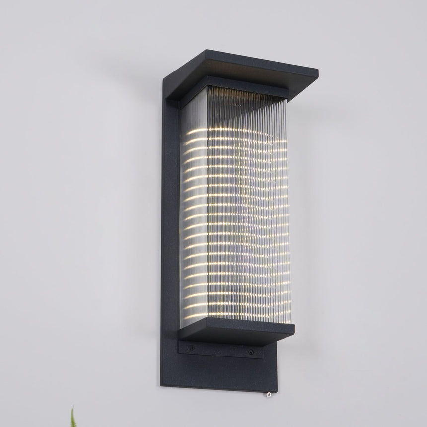 The lantern lit on a gray wall, the light banded by the ribs