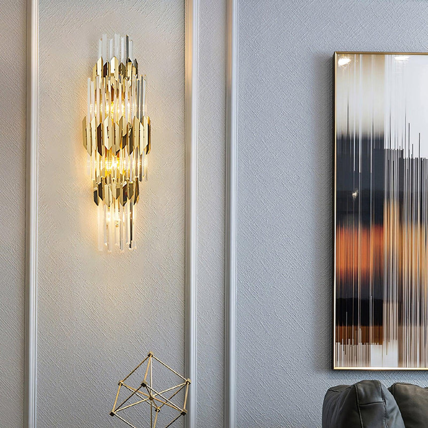 The sconce lit on a pale wall beside an abstract painting above a chair