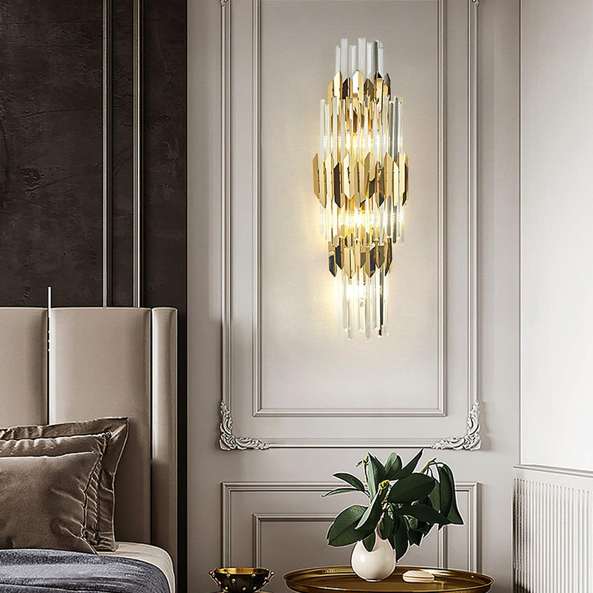 The sconce on a white paneled wall beside a headboard above a plant