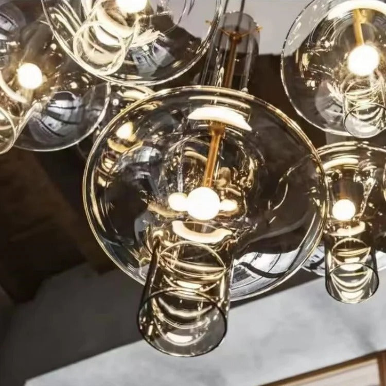 A cluster of amber and smoke spindles lit above a dining setting