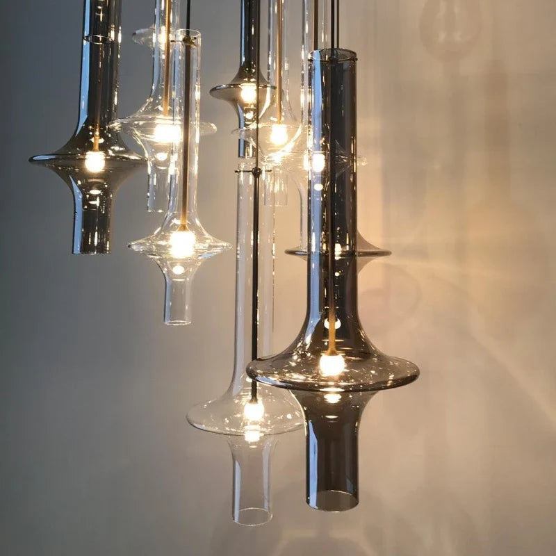 A row of tapered smoke glass spindles lit in front of a dark wall