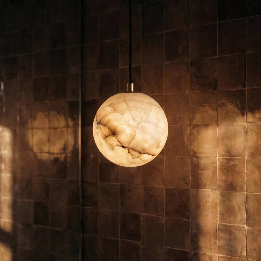 One lit alabaster sphere against a wall of dark glazed tile