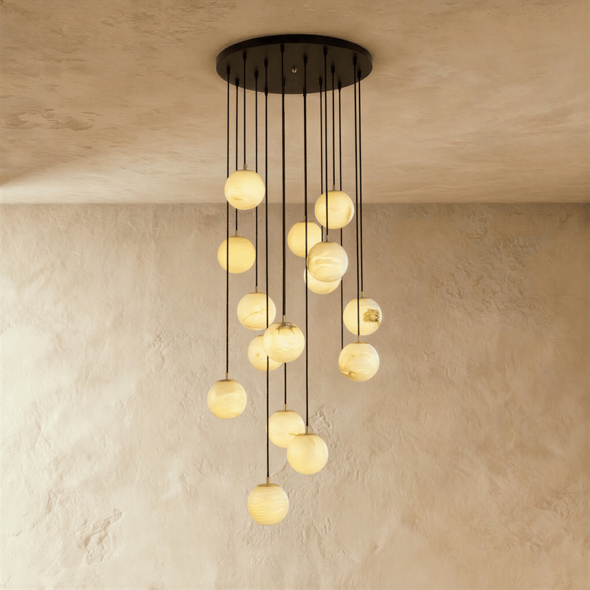 Fifteen lit stone spheres in a long cascade from a wide black ceiling plate