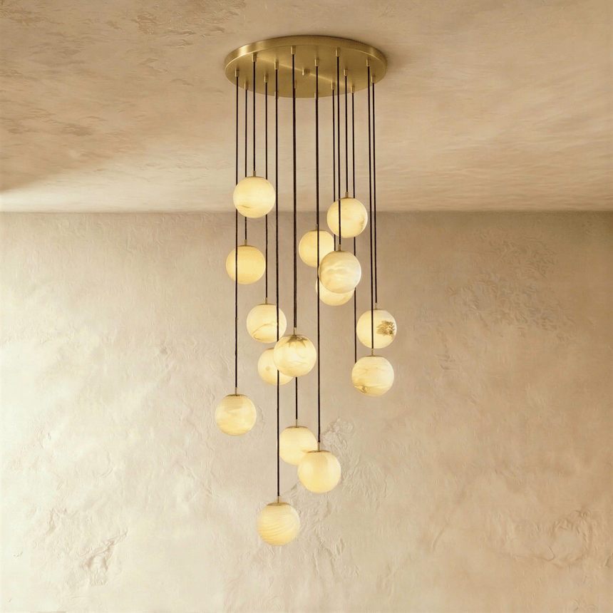 Fifteen lit stone spheres in a long cascade from a brass ceiling plate