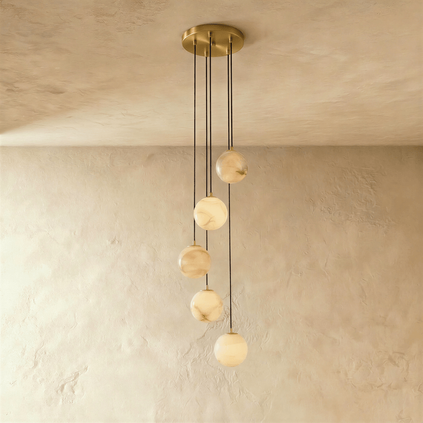 Five lit stone spheres at stepped heights below a brass ceiling plate