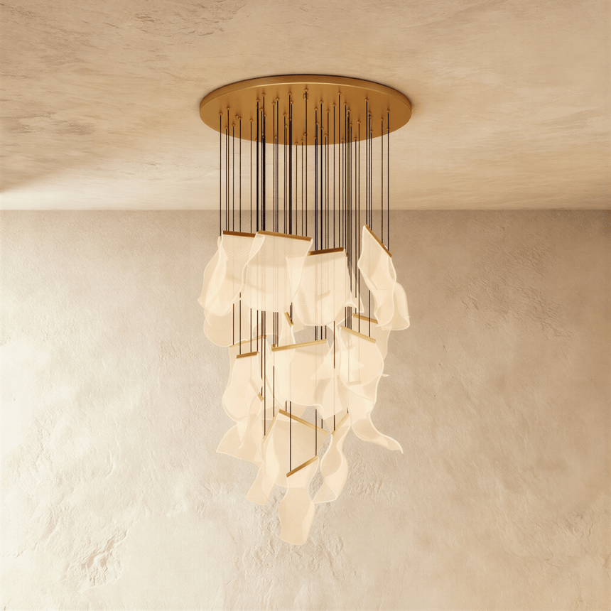 A tall cascade of curved lit acrylic sheets falling from a round gold ceiling canopy