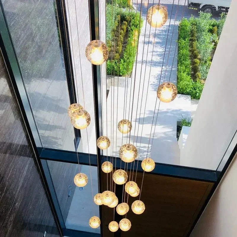 Amber lit spheres seen through a tall window with a garden beyond