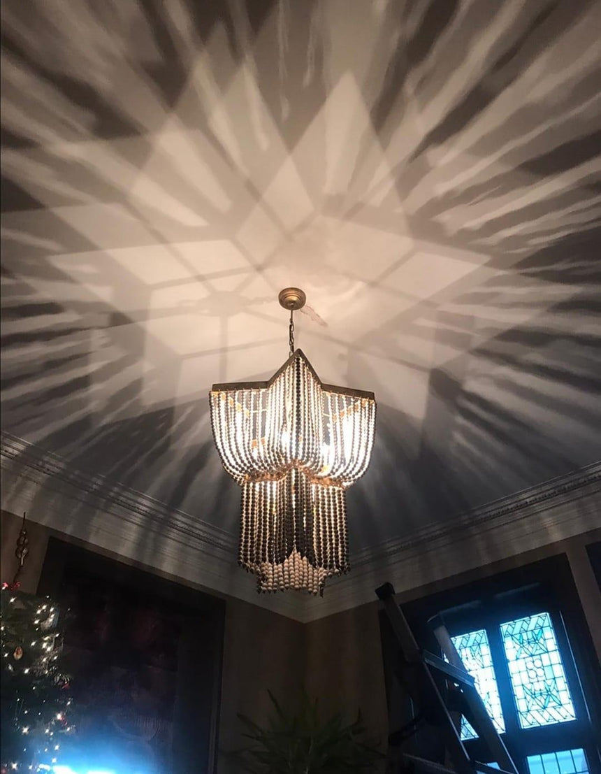 Lit in a dark room, the strands throwing a wide star pattern across the ceiling