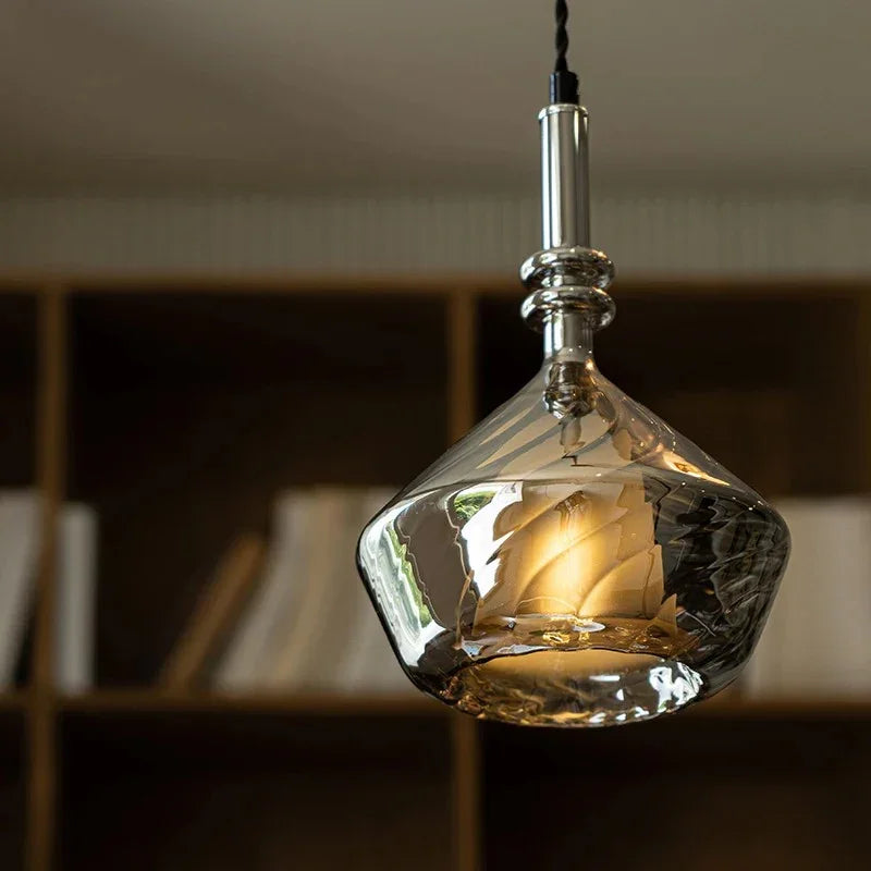The faceted amber shade lit above a shelf with the facets catching light