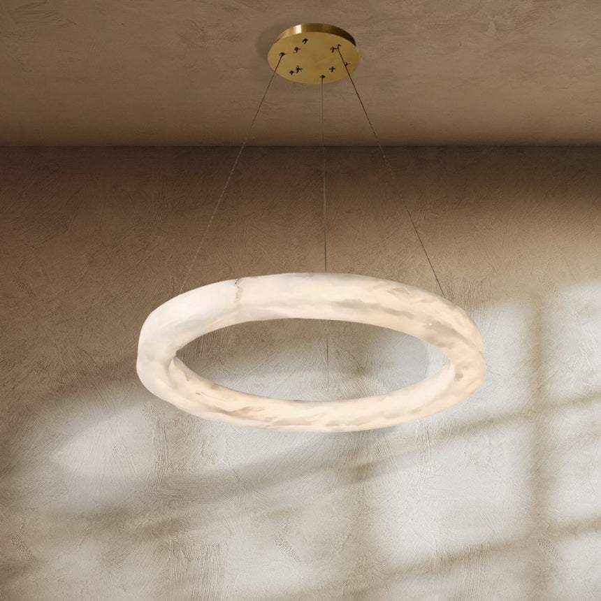 The lit ring on a plaster ceiling with sunlight falling across the wall