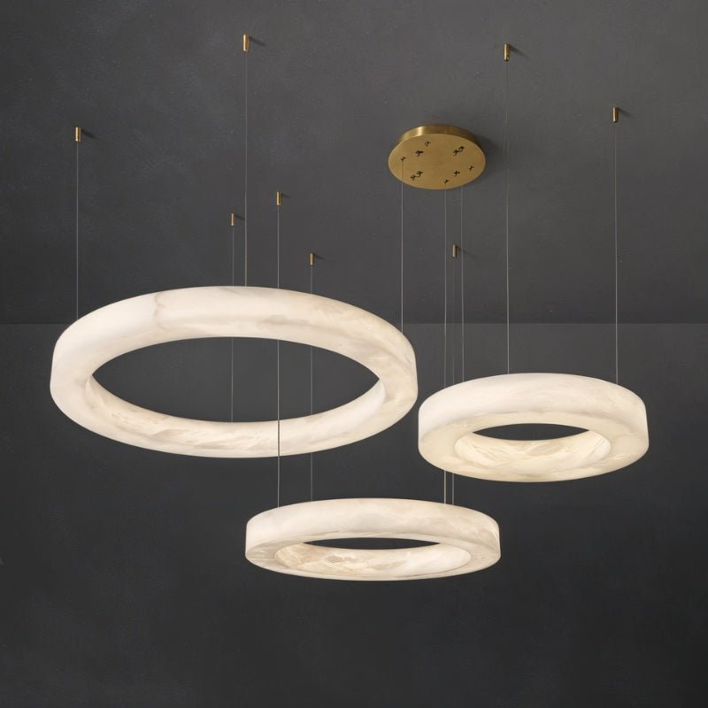 Three alabaster rings at staggered heights against a dark background