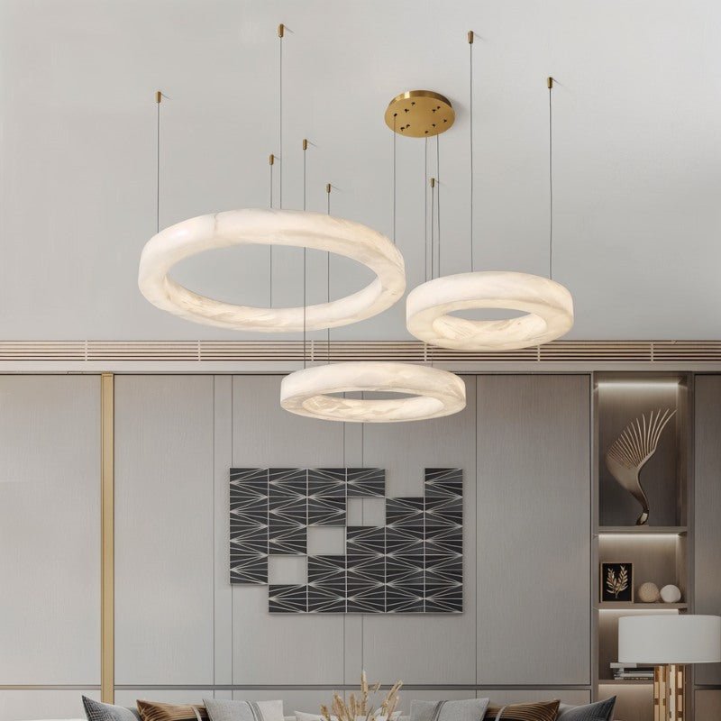 Three stone rings at different heights in a living room with artwork on the wall