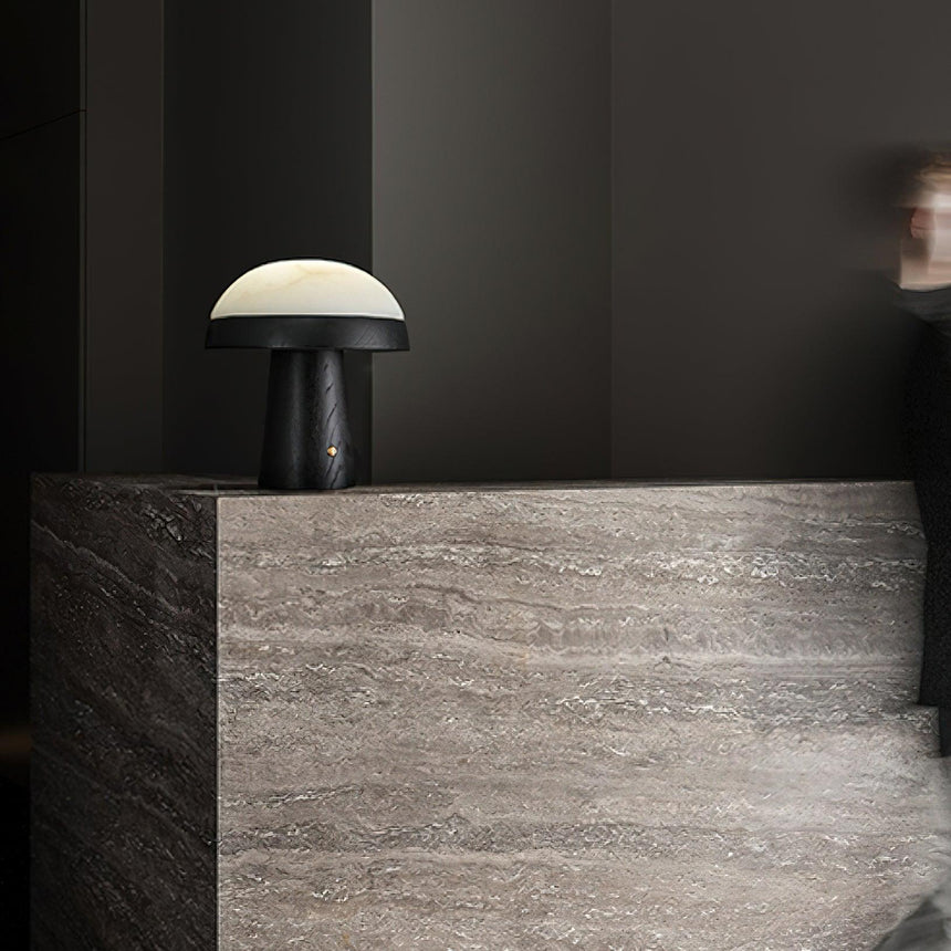 Stone table lamp lit on a stone ledge in a dim room