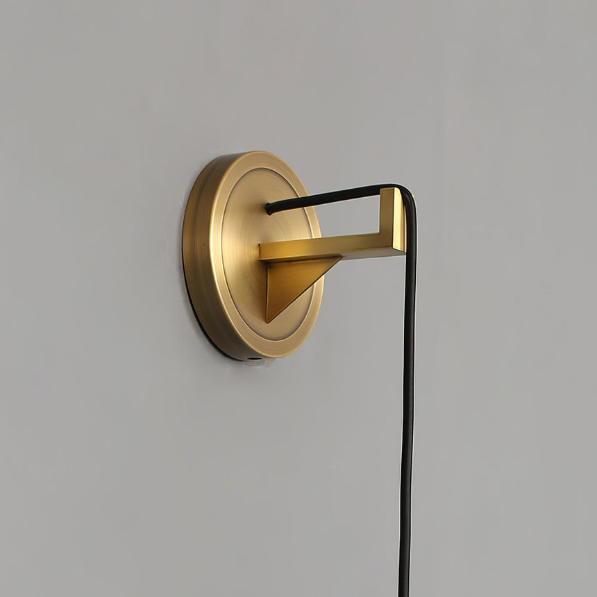 Close view of the round brass bracket and the cord leaving it