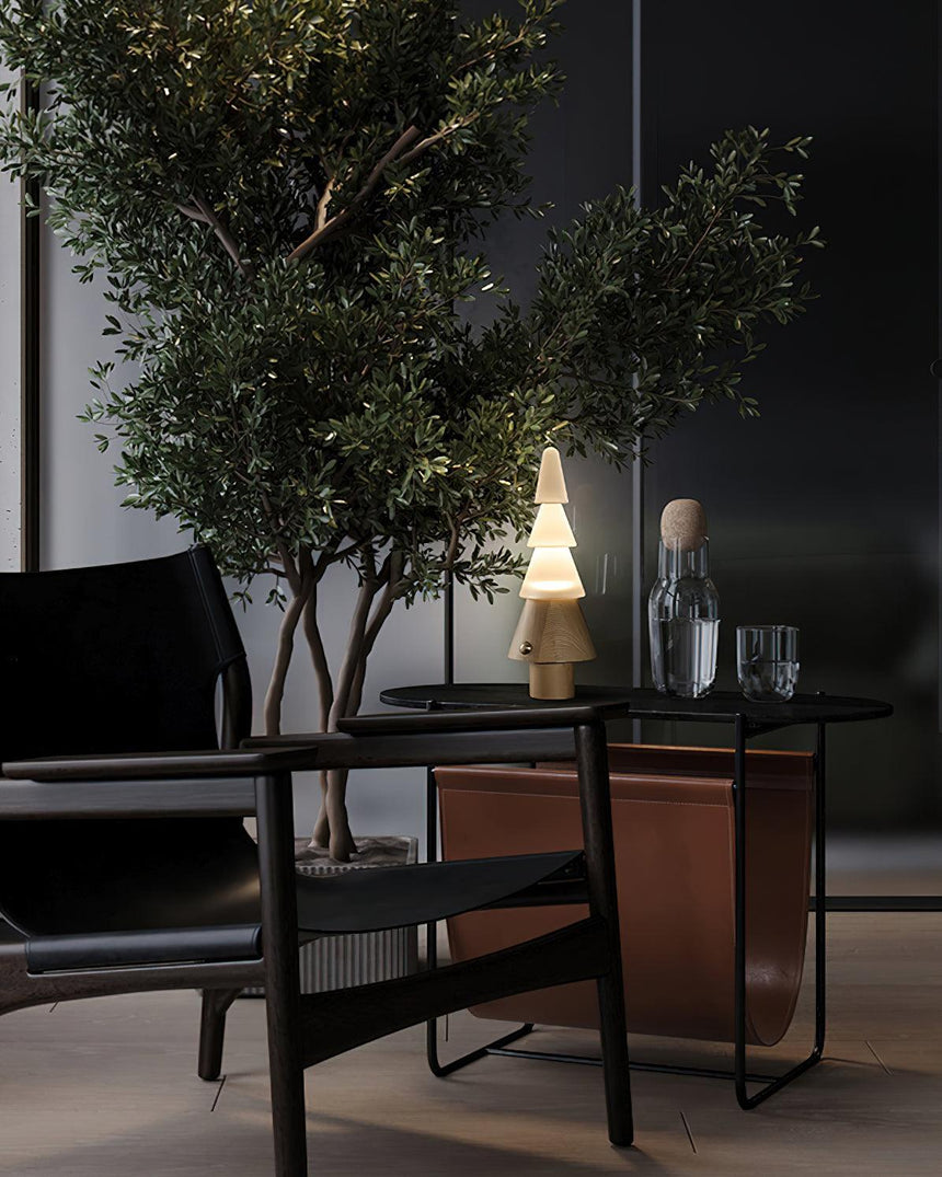 Table lamp with night light lit on a dark table beside an olive tree